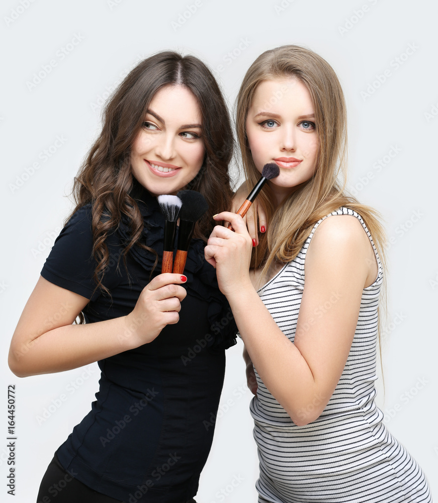 Applying Make-up. Woman with a brush for make-up.Female friends putting makeup Applying Make-up. Woman with a brush for make-up.Female friends putting makeup
