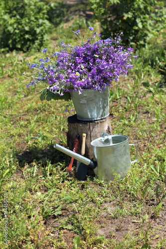 summer decoration for a private plot / Installation with a large bouquet of wildflowers and a garden tool 