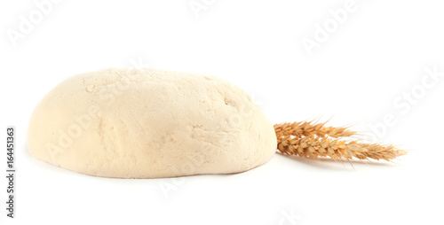 Fresh raw dough and wheat on white background