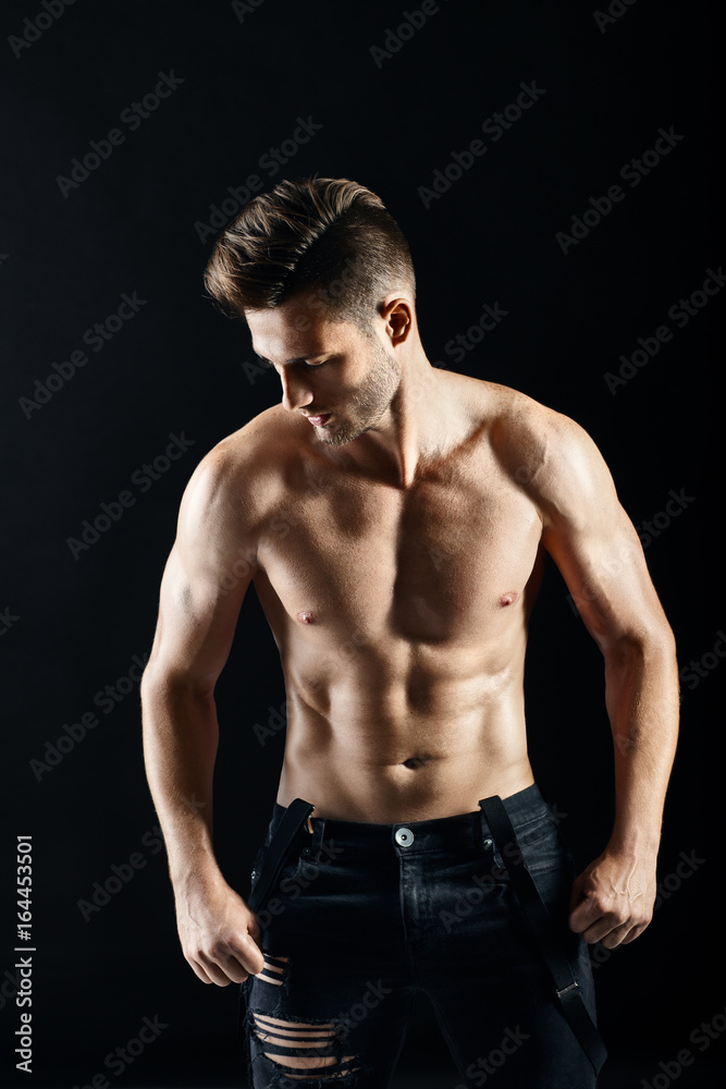 Portrait of a sexy muscular shirtless man on dark background Portrait of a sexy muscular shirtless man on dark background