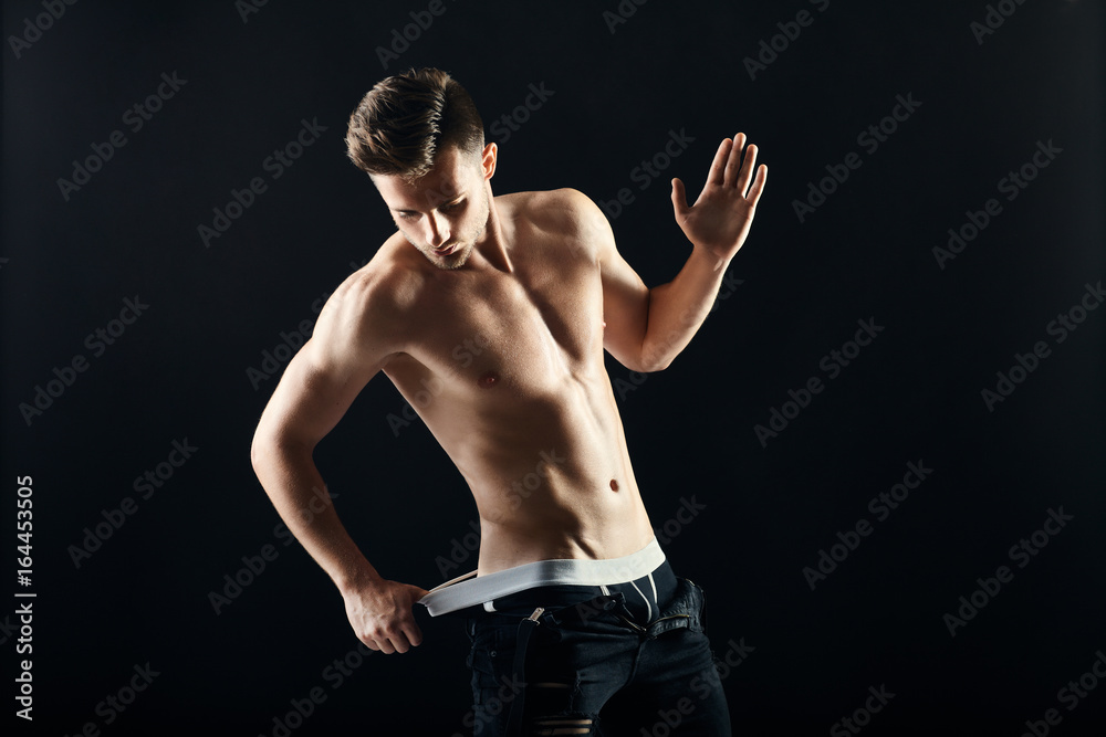 Portrait of a sexy muscular shirtless man on dark background