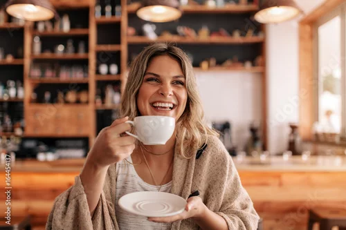 Obraz Smiling young woman having coffee