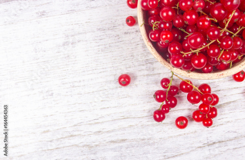 Fresh ripe red currants on rustic wood background.
