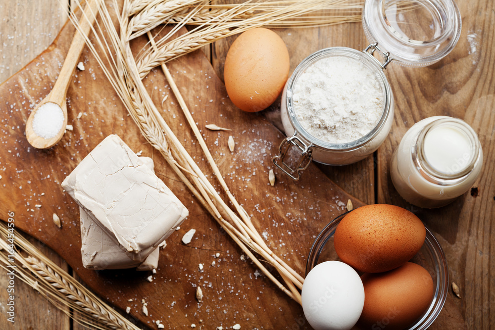Fotografie Fresh yeast and ingredients for baking on rustic kitchen table from above