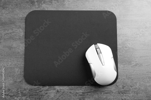 Принти на полотні Blank mat and wireless mouse on textured background