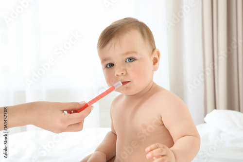 Mother holding oral dosing ...