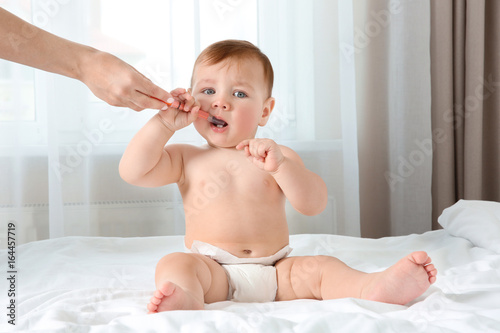 Mother holding oral dosing ...