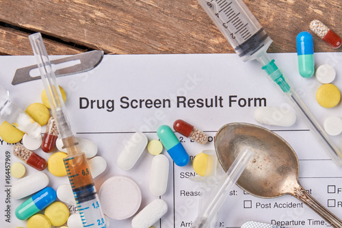 Drug screen result form, syringes, spoon. Result of drugs overdose. photo