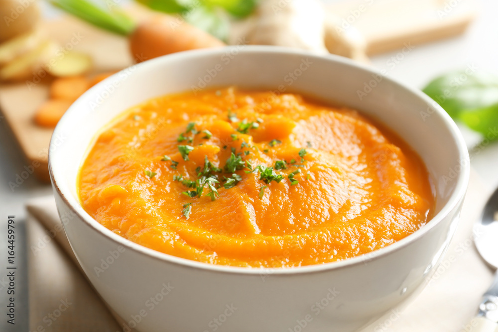 Delicious carrot soup on table, closeup Delicious carrot soup on table, closeup