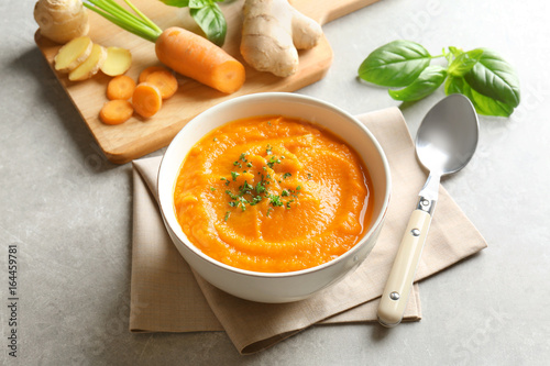 Delicious carrot soup on gray table