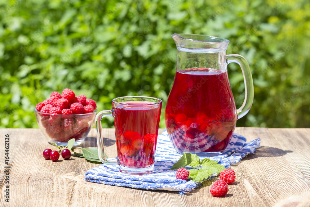 Red compote with cherry, strawberry, gooseberry nd raspberry on wooden table Red compote with cherry, strawberry, gooseberry nd raspberry on wooden table