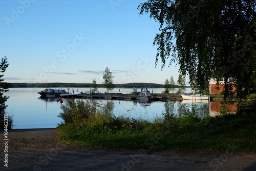 Bateaux amarrés au ponton d'un lac en Finlande sous le soleil de minuit