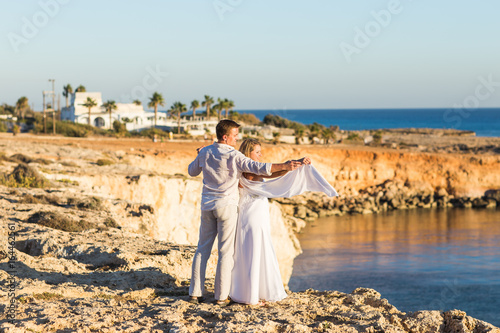 Romantic dating. Young loving couple walking together by the beach enjoying sea photo