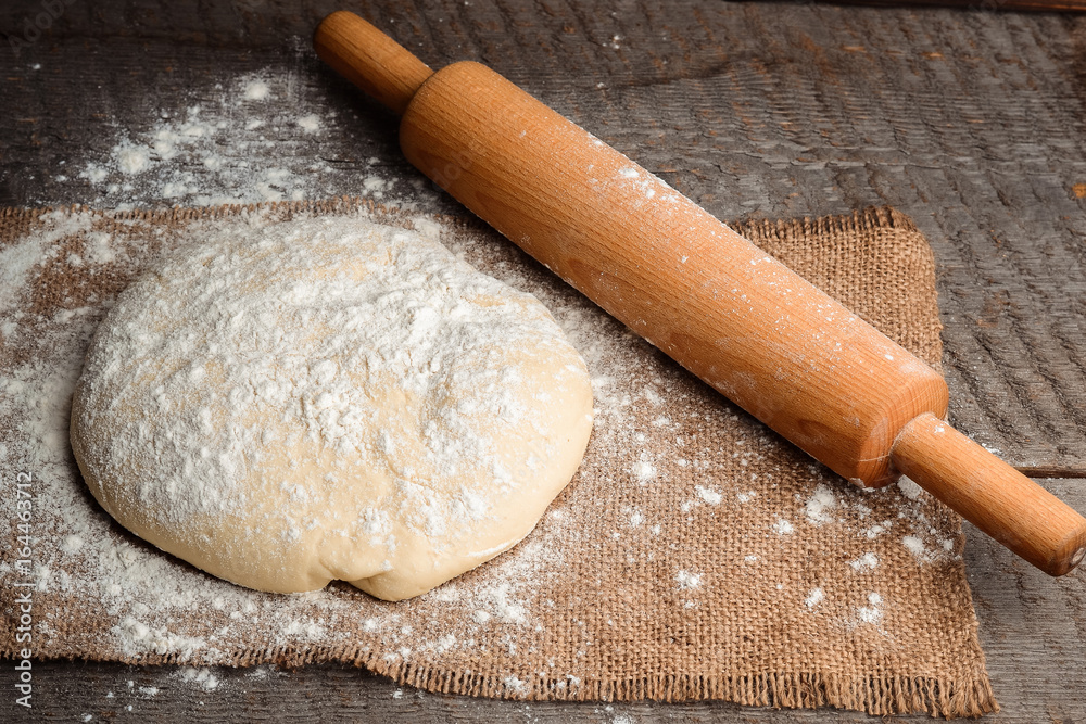 Ball of dough and rolling pin on rustic background Ball of dough and rolling pin on rustic background