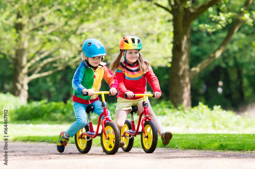 Fototapeta premium Kids ride balance bike in park