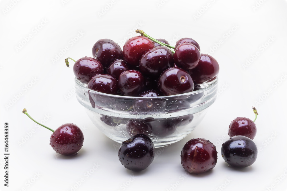 Glass vase with wet cherry berries on white background Glass vase with wet cherry berries on white background
