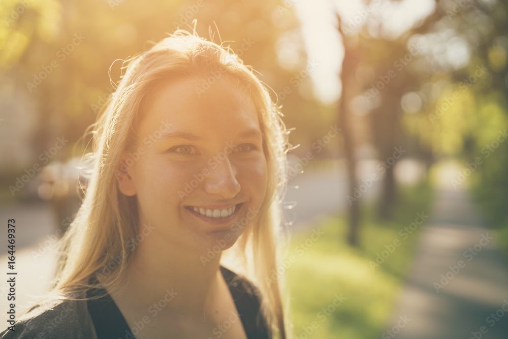 teen girl smiling in green town in sunny summer evening teen girl smiling in green town in sunny summer evening
