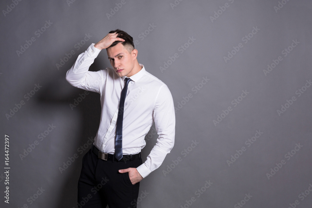 Confident businessman at gray studio background