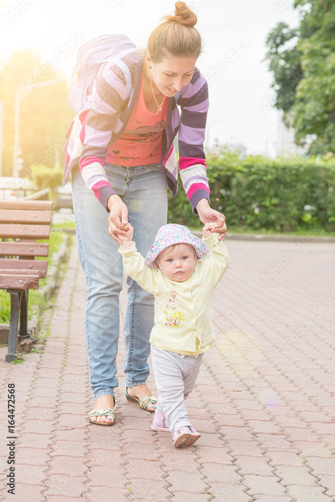 Fototapeta premium Baby first steps with mom