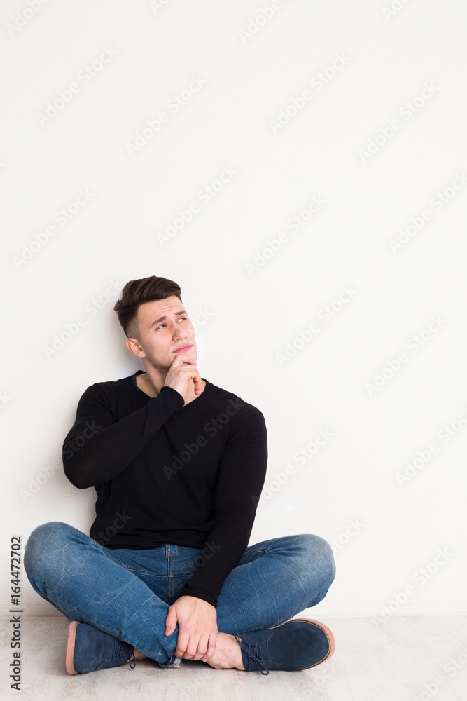 Pensive young man portrait at white studio background. Pensive young man portrait at white studio background.