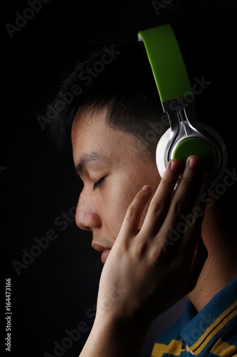 Teen listening to music on a headphone photo