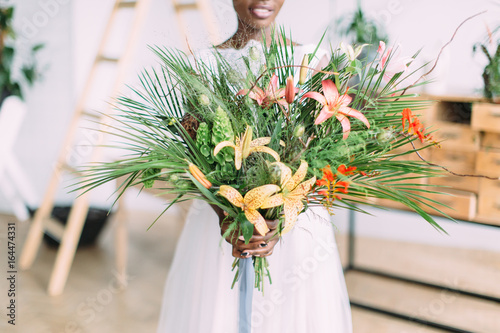 Beautiful african american bride with tropical bouquet in the studio