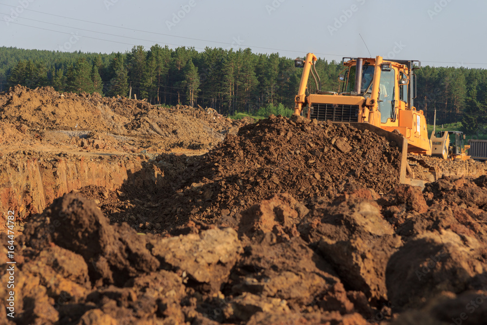 A bulldozer moves the soil bucket during A bulldozer moves the soil bucket during