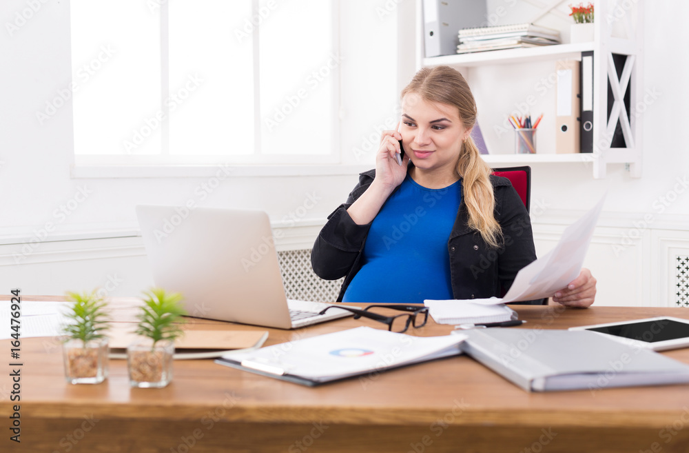Pregnant business woman talking on phone at office Pregnant business woman talking on phone at office
