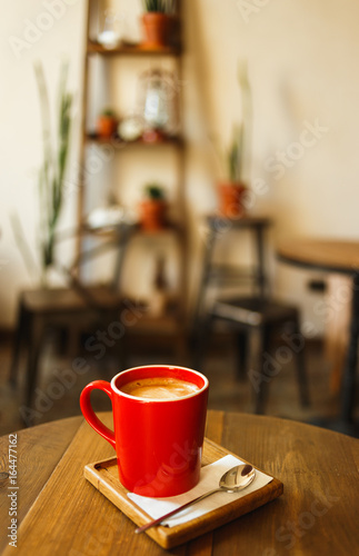 Fototapeta Naklejka Na Ścianę i Meble -  Red cup of coffee in a cafe on table. Place for rest