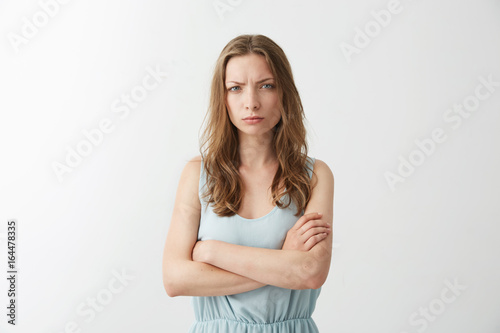 Photography Offended displeased young girl frowning looking at camera with crossed arms over white background