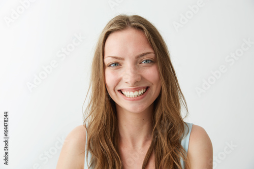 Beautiful sincere happy girl smiling laughing looking at camera over white background.