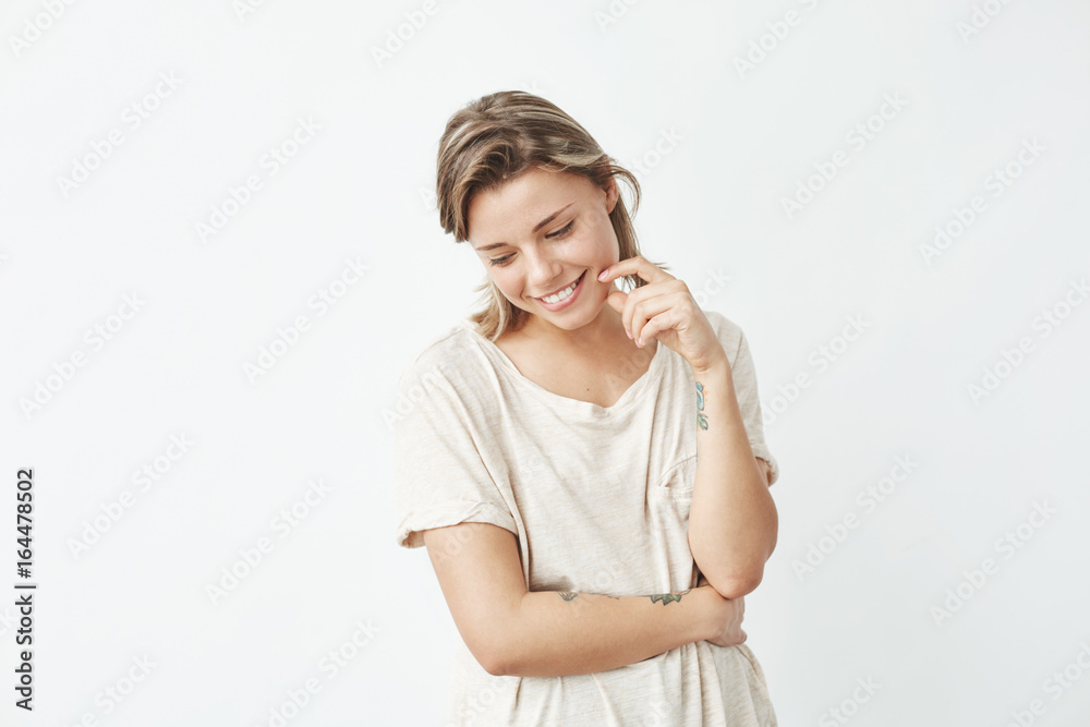 Portrait of young beautiful shy girl smiling looking down over white background. Portrait of young beautiful shy girl smiling looking down over white background.