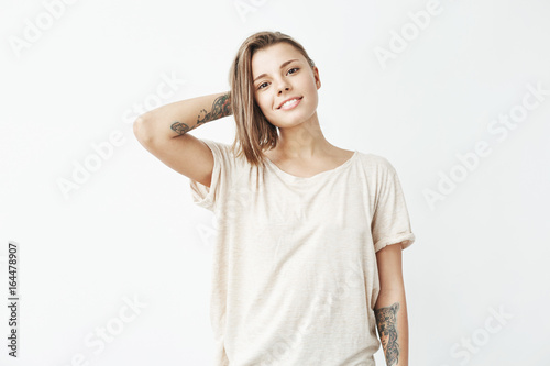 Portrait of young beautiful tattooed girl smiling posing looking at camera over white background.