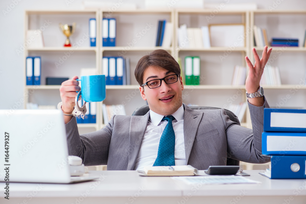 Businessman chained with handcuffs to his coffee Businessman chained with handcuffs to his coffee