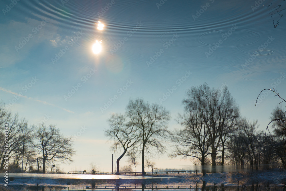 Spiegelung einer Winterlandschaft in einem See, Hessen, Deutschland