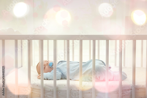 Cute little baby sleeping in cradle at home photo