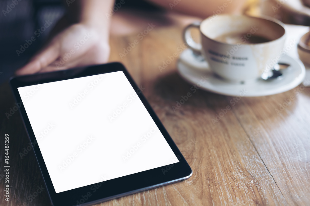 Mockup image of hands holding , showing and giving black tablet pc with blank white screen to somwone on vintage wooden table with coffee cup Mockup image of hands holding , showing and giving black tablet pc with blank white screen to somwone on vintage wooden table with coffee cup