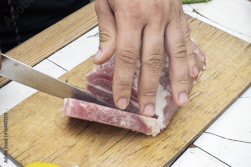 Cutting a piece of meat on a wooden cutting board