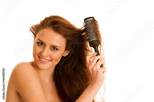 Beautiful young woman combs her hair with a brush isolated over white background