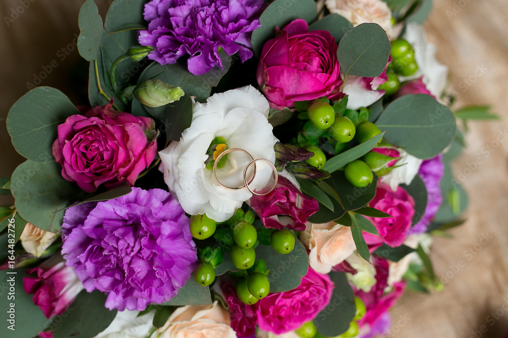 wedding bouquet of peonies with wedding rings