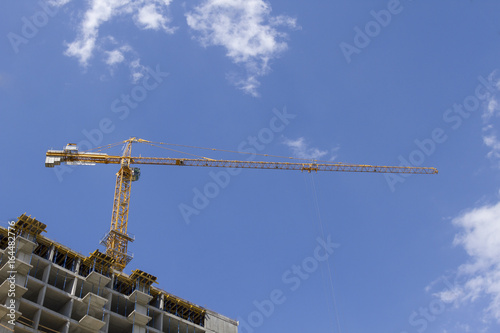 Crane and building construction on sky background photo