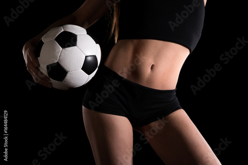 Torso of a sexy woman with a football