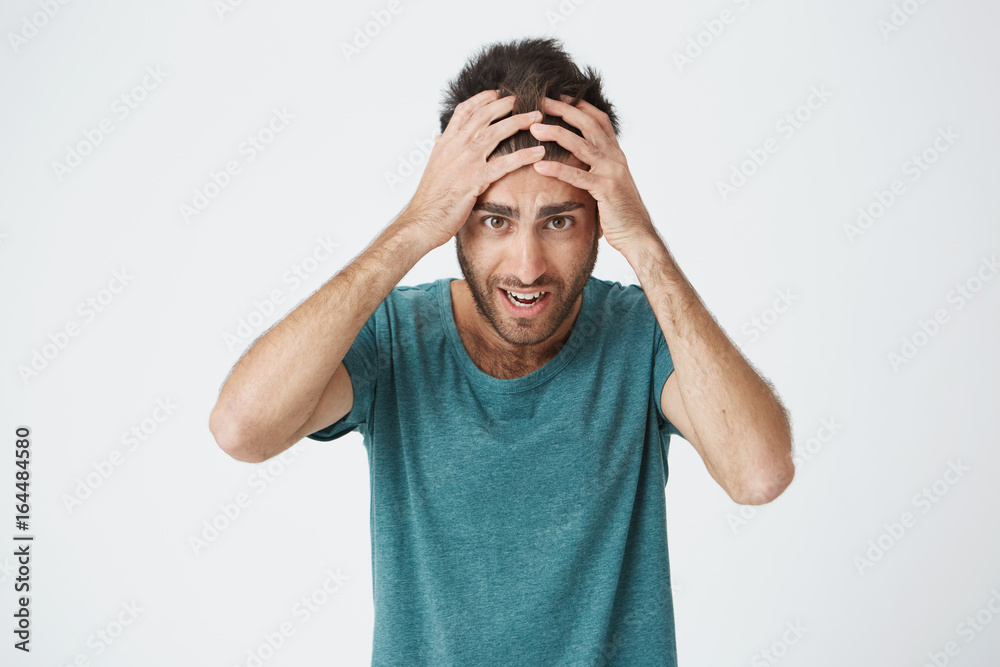 Oh no Desperate, stressed young european man looking at camera in terror and shock, keeping mouth open, holding head, shocked by the quantity his of problems. Oh no Desperate, stressed young european man looking at camera in terror and shock, keeping mouth open, holding head, shocked by the quantity his of problems.