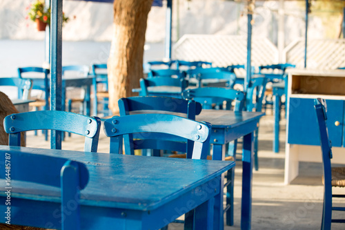 Tables and chairs in a street restaurant in Kamari on Santorini