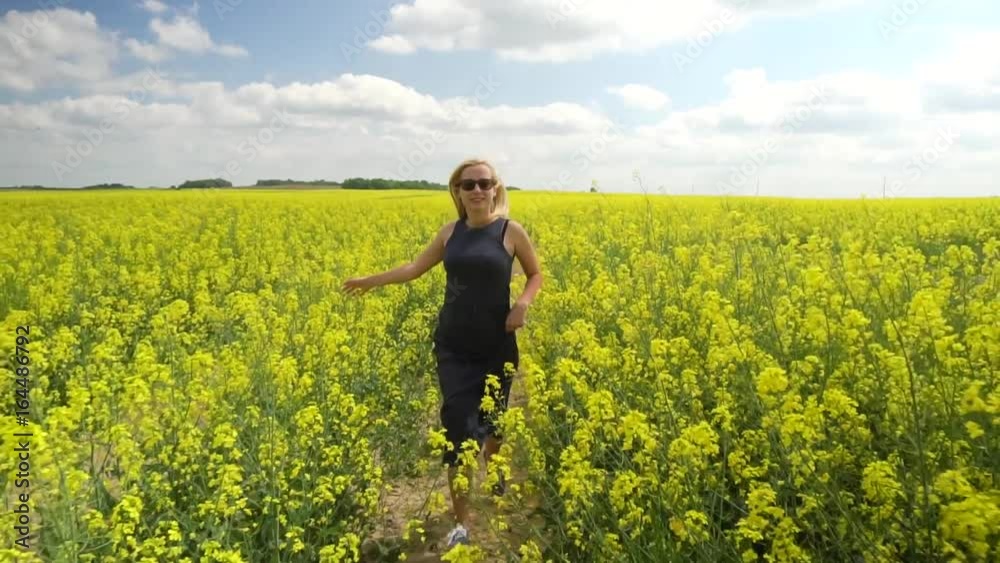 young blonde woman posing in beautiful rapeseed field young blonde woman posing in beautiful rapeseed field