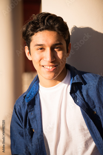 Handsome hispanic young adult, smiling and looking at camera
 photo