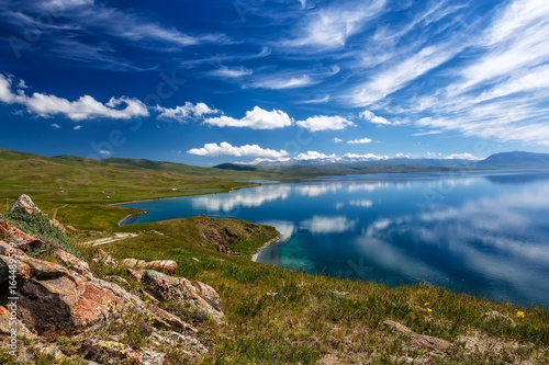 Mountain Song Kol lake. Beautiful clouds reflected in water. Kyrgyzstan.