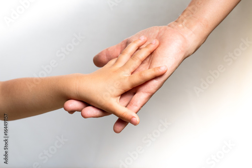 Close up of a woman's hand holding a child's hand
