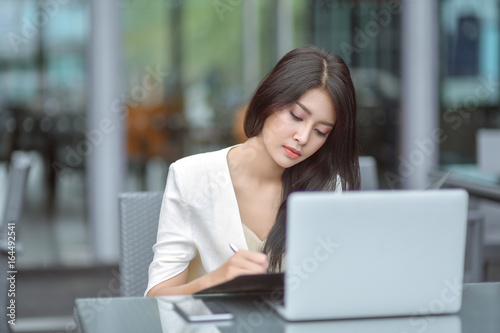Young woman sitting in a cafe with her laptop, Stressful for work.