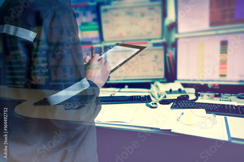 Double exposure of  Engineer or Technician man in working shirt  working with tablet in control room of oil and gas platform or plant industrial for monitor process, business and industry concept